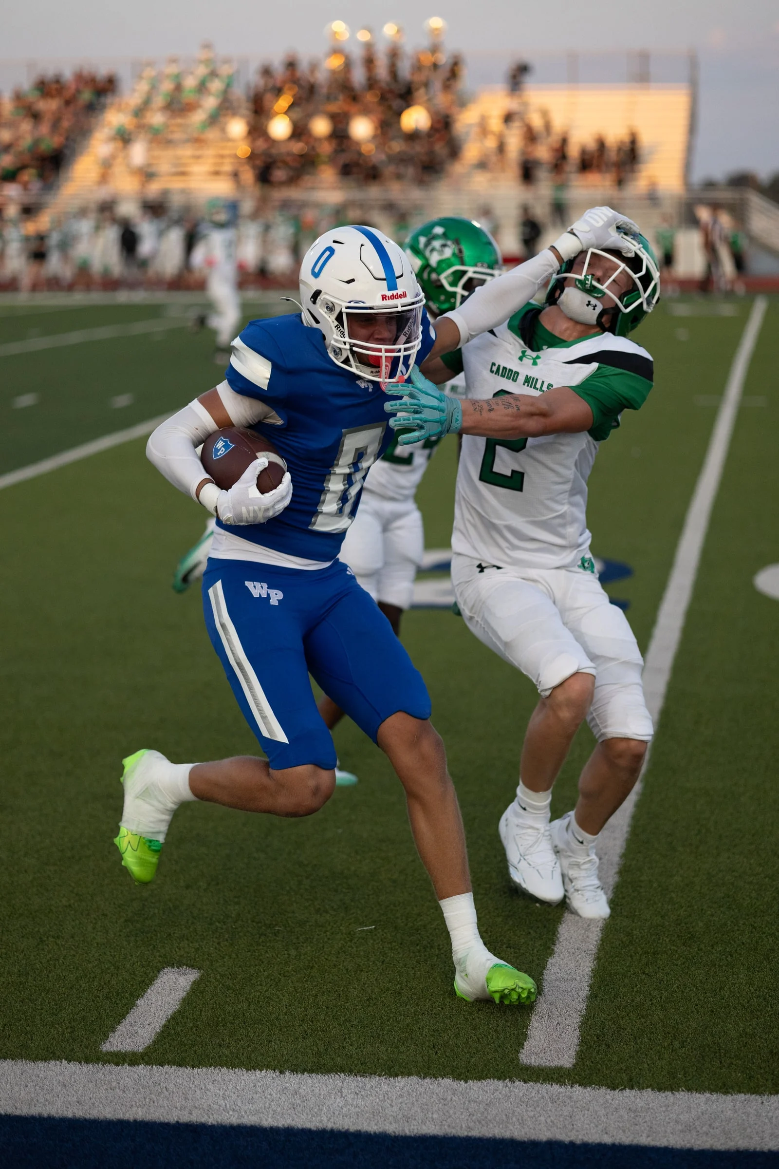 Number 0 with the ball, stiff-arming a Caddo Mills defender, straight off the camera